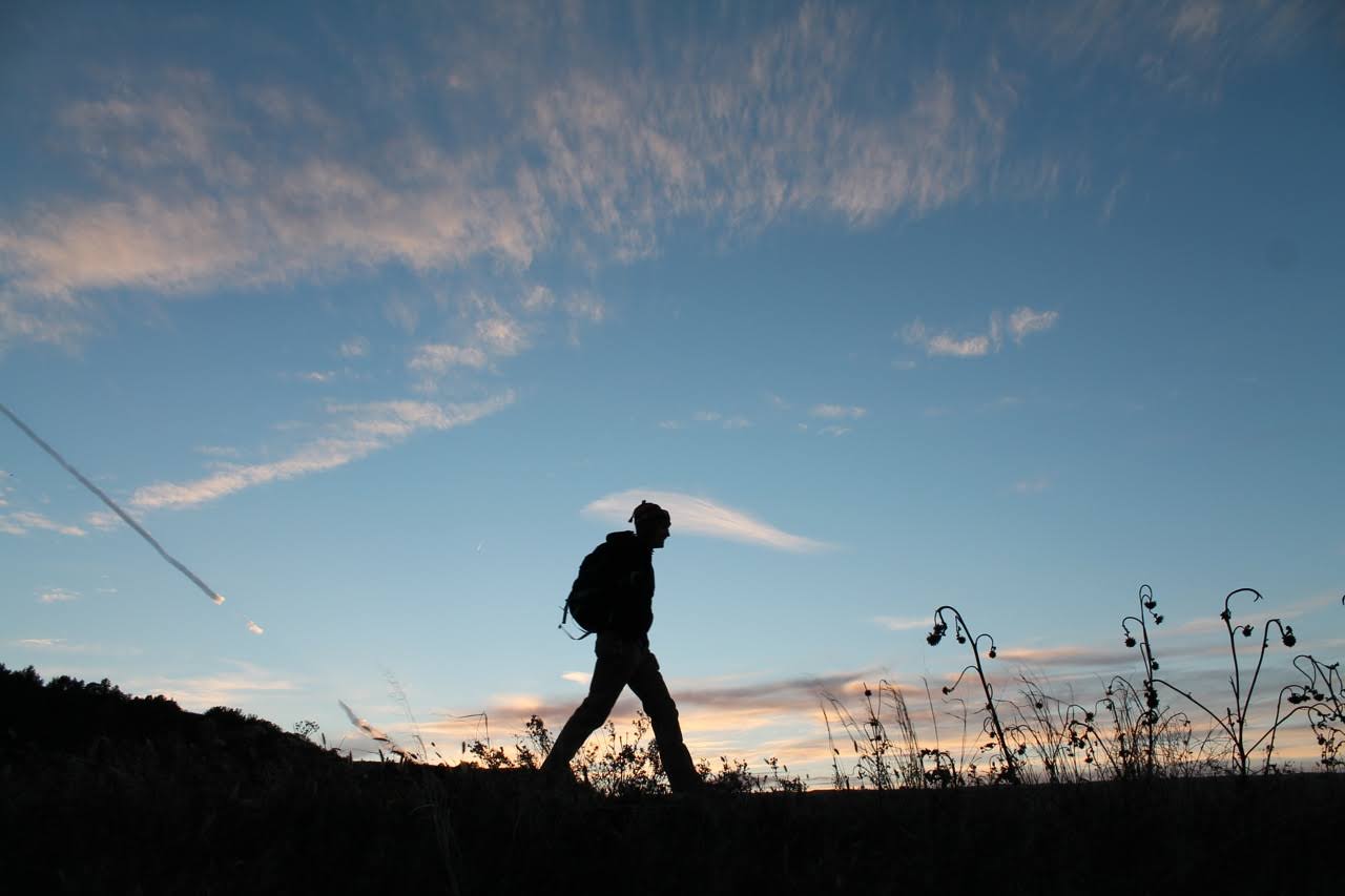 Student walking at sunset