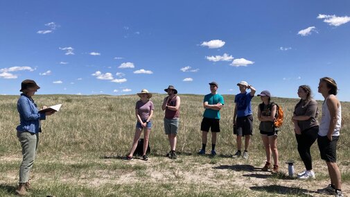 Dr. Rau reading an excerpt to class in the prairie.