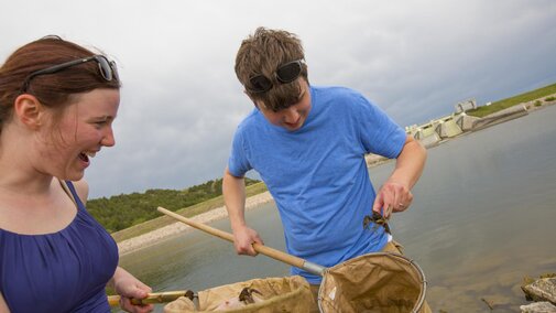 Students collect a crawfish from the water nets