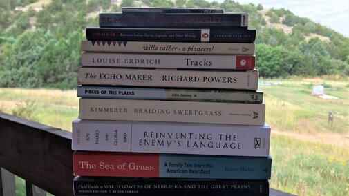 A stack of books balanced on the railing of Prickly Pear