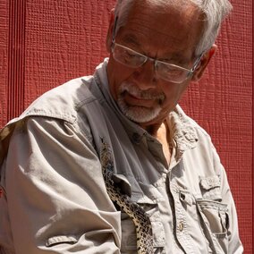 Dennis with a bull snake climbing on him